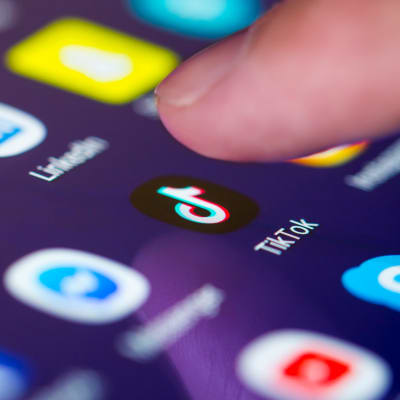 Ett finger syns över TikToks ikon på en smarttelefon.