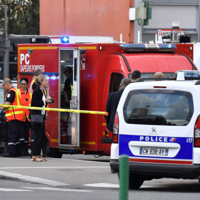 Polisbilar och ambulanser på en gata.