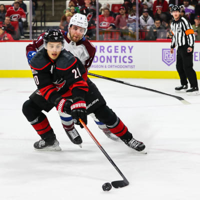 Carolinan Sebastian Aho ja Coloradon Evan Rodrigues kamppailevat NHL-ottelussa.