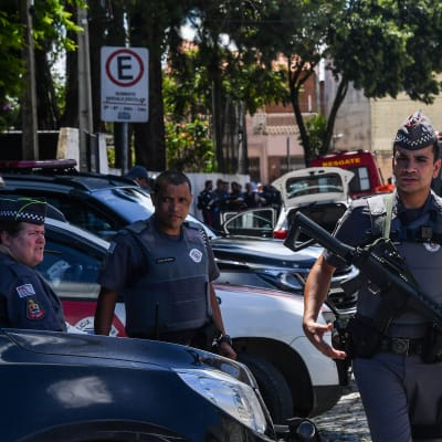 Poliser utanför en skola i Suzano i närheten av São Paulo, där en gärningsman sköt ihjäl flera personer.