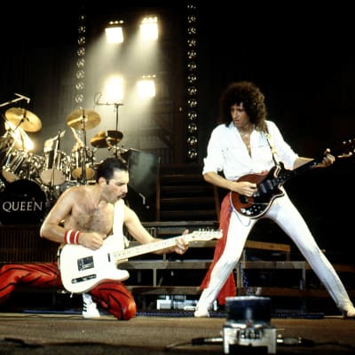Queen live i Belgien 1982. Freddie Mercury på knä spelar gitarr bredvid Brian May.