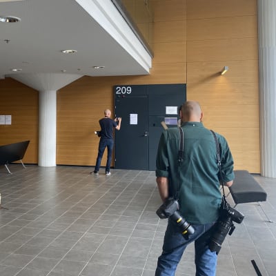 Reportrar och fotografer väntar på att dörrarna till rättssalen ska öppnas.