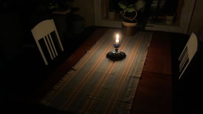 Ett tänt ljus på ett bord.