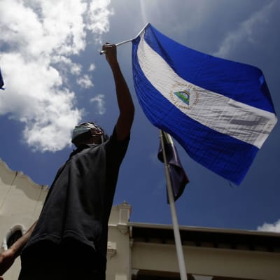 Man håller i Nivaraguas flagga under demonstrationer mot president Ortega