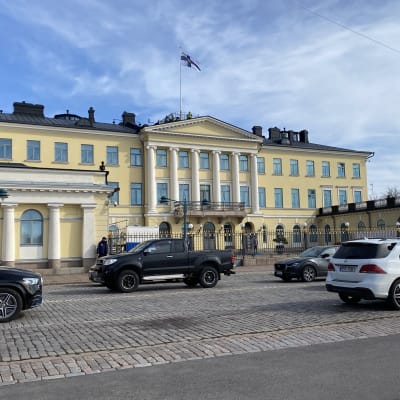 Bilar på gatan framför Presidentens slott i Helsingfors.