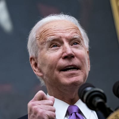 Joe Biden står vid ett podium och talar. 