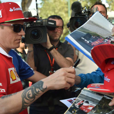Kimi Räikkönen jakamassa nimikirjoituksia.