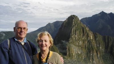 Peje och Pearl vid Machu Picchu. Båda ler mot kameran och har spetsiga berg i bakgrunden.