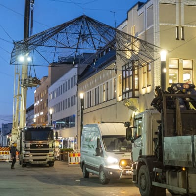 Kuorma-auto, pakettiauto ja nosturiauto jouluvalojen asennustyössä Oulun rotuaarilla.