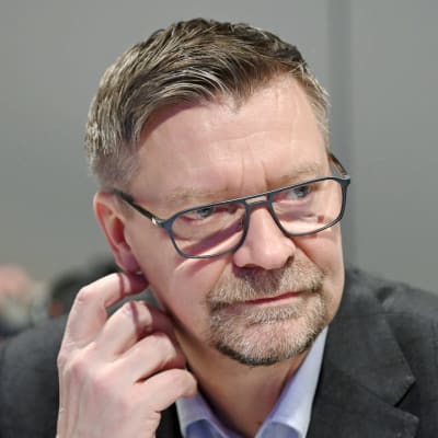 Jukka Jalonen för handen mot örat.