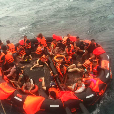 Turistiveneen kaatumisesta pelastettuja ihmisiä nostetaan pelastuslautalta kalastusaluksen kyytiin Phuketin edustalla. Valtaosa ihmisistä oli kiinalaisia turisteja.