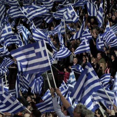 Greker viftar med falggor under valmöte inför det grekiska parlamentsvalet 25.1.2015