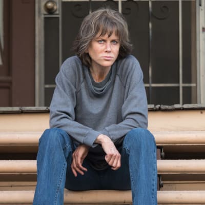 Erin Bell (Nicole Kidman) sitter på en trappa och ser trött ut.