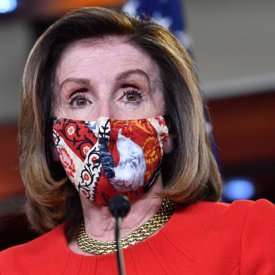 Nancy Pelosi iförd i ett mönstrat munskydd.