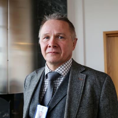 Leif Malmberg i en grå kavaj och slips och skjorta tittar in i kameran.