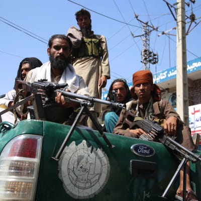 Tuiman näköisiä talibantaistelijoita avolava-auton kyydissä.
