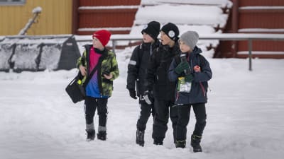 Lapset katsovat jalkapallopelia Oulunkylän urheilukentällä