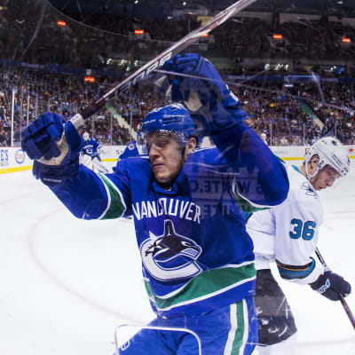 Vancouver Canucks spelare Jannik Hansen trycks upp mot sargen.