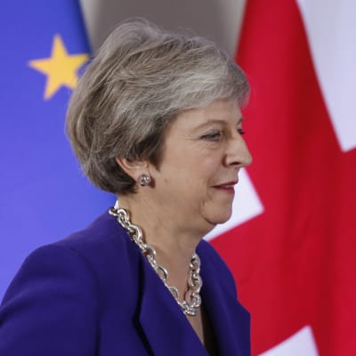 Theresa May i profil, i bakgrunden EU:s och Storbritanniens flaggor.