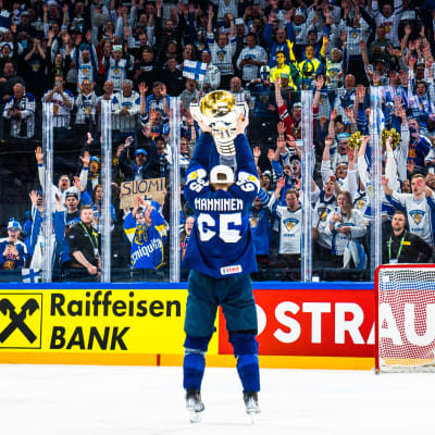 Sakari Manninen lyfter VM-bucklan framför publiken.