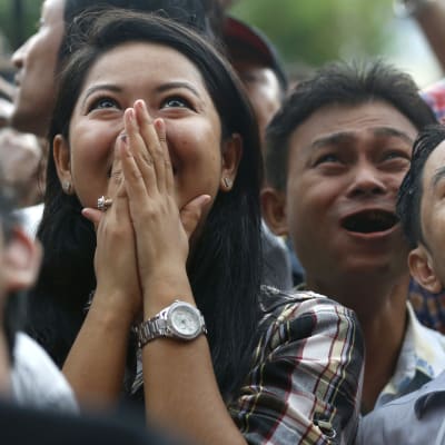 Anhängare av Aung San Suu Kyis parti NLD reagerar med glädje då de ser på den pågående rösträkningen i Rangoon, Burma.