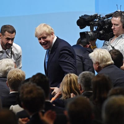 Boris Johnson omringad av kameror.