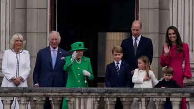 Kungafamiljen med Elizabeth II i mitten vinkar från balkongen.