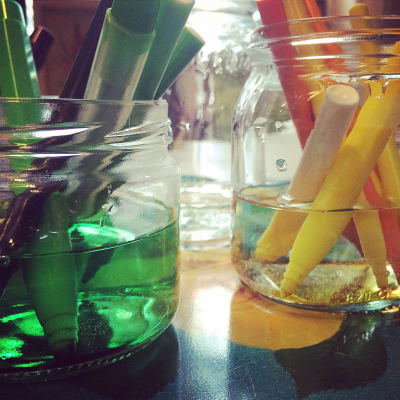 Tuschpennor i glasburkar fyllda med vatten