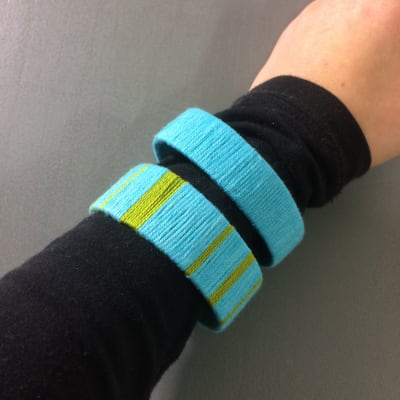 Arm med två armband gjorda av garn.