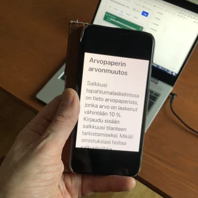 Bild av en  mobiltelefon som visar texten: Arvopaperin arvonmuutos. 