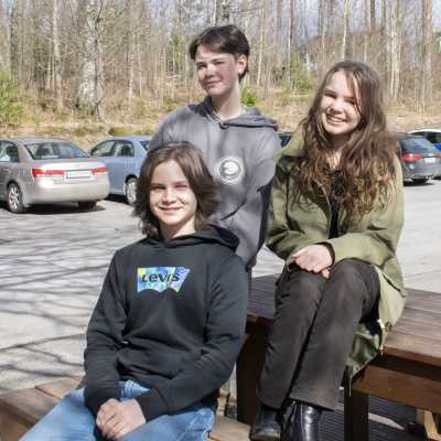 Tre ungdomar på en bänk