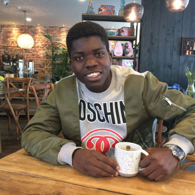 Serge Atakayi sitter på café i Jakobstad, juni 2017.