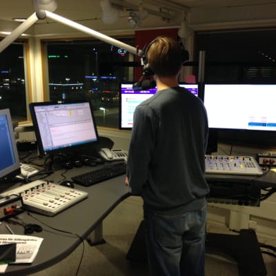 Bild av reporter bakifrån i Yle Åbolands radiostudio.