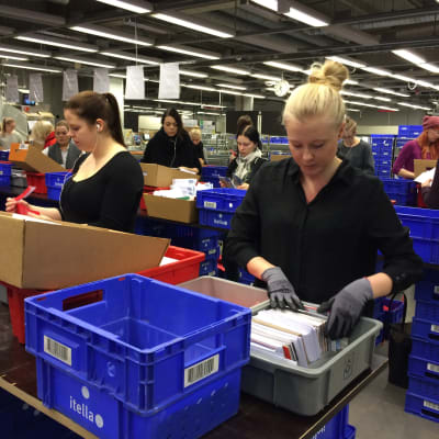Emma Kauppila (t.h.) sorterar julhälsningar på sorteringscentralen.