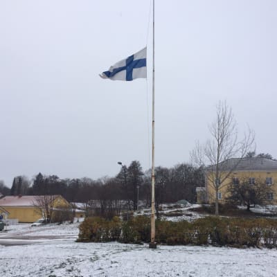 Finlands flagga på halvstång.