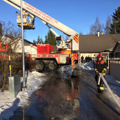 Brandkåren i arbete vid egnahemshus som brunnit i Parkstad i Helsingfors