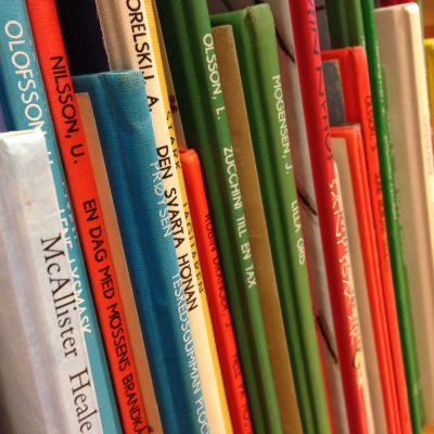 Färggranna barnböcker i en bokhylla.