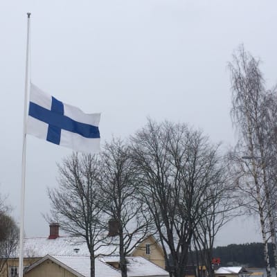 Finlands flagga på halvstång.