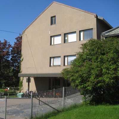 Beige betonghus i fyra våningar.