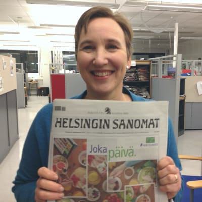 Paula Salovaara visar upp Helsingin Sanomat i tabloidformat