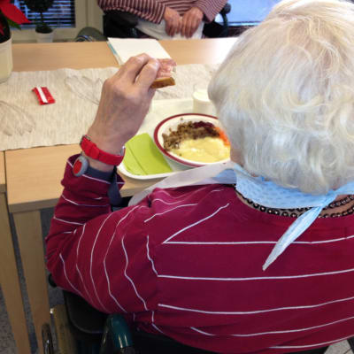 Äldre person äter.