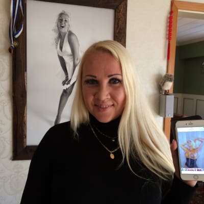 Kvinna håller i telefon där en erotisk målad bild av henne visas