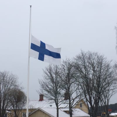 Finlands flagga på halvstång.