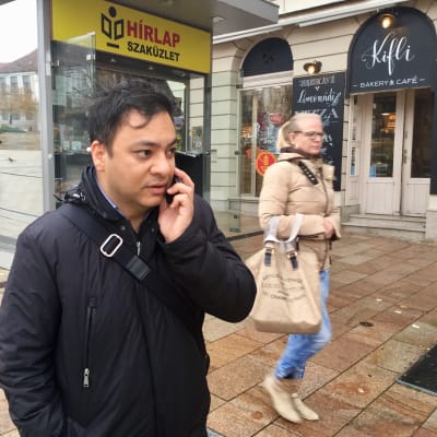 Attila Babos talar i telefon medan han står på gatan i den ungerska staden Pecs