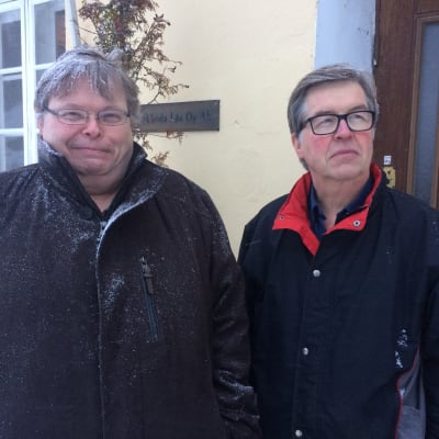Två män utanför en kontorsbyggnad.