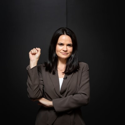 Belarus oppositionsledare Svetlana Tichanovskaja mot en svart bakgrund. Hon håller högra handen i en knytnäve och poserar med handen uppe.