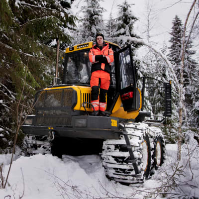 Metsäkoneen kuljettajaksi opiskeleva Juuso Lehtomäki seisoo kädet puuskassa ajokoneen ylätasanteella