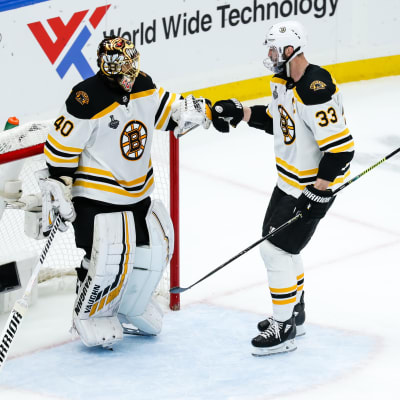Boston Bruinsin pelaajat Tuukka Rask ja Zdeno Chara onnittelevat toisiaan voitetun ottelun jälkeen maalin edustalla.