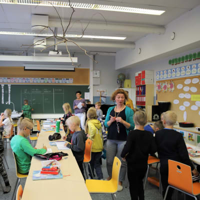 Aapiskujan koulun kakkosluokkalaiset opiskelevat kahden opettajan opastuksella. Oikealla Henna Hernesniemi ja luokan edessä Heini Ylisuutari.