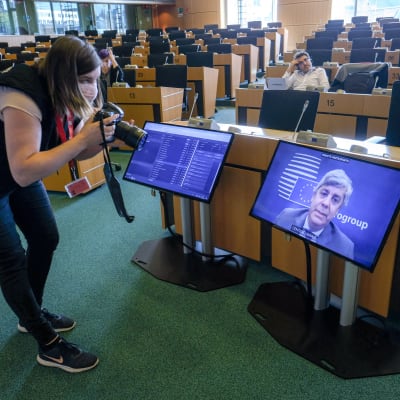 Valokuvaaja ottaa kuvaa televisioruudusta, jossa Euroryhmän puheenjohtaja Mario Centeno.
